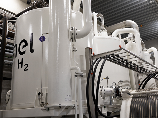 Nel Hydrogen electrolyzer gas tanks lined up in a factory.