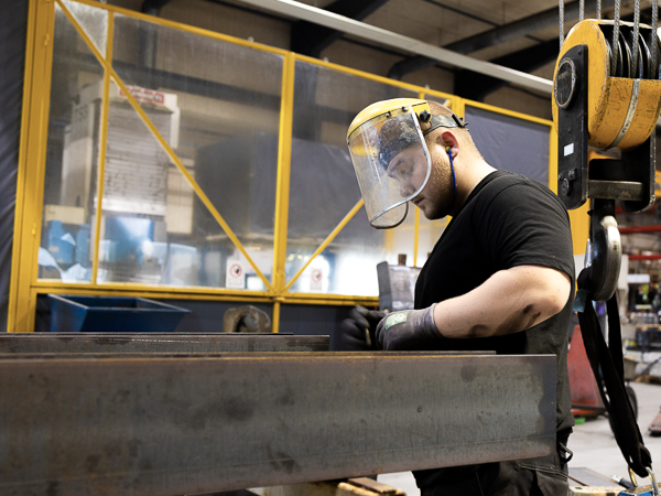 AS SCAN employee measuring a large steel beam