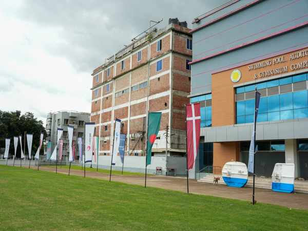 Entrance area of the Modern Fishing Equipment Seminar & Exhibition 2025 in Bangladesh, with national flags including Denmark and Bangladesh.