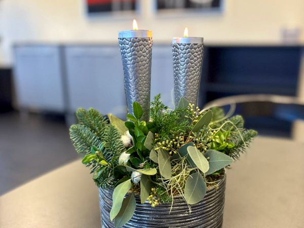 Green Christmas arrangement with a light placed on a desk in the AS SCAN office.