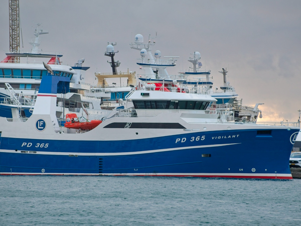 Den pelagiske trawler PD 365 Vigilant, bygget af Karstensens Skibsværft, ligger ved kaj. Skibet er malet i hvidt og blåt med Lunar Fishing Companys logo (LF) på skorstenen og navnet Vigilant tydeligt på skroget.