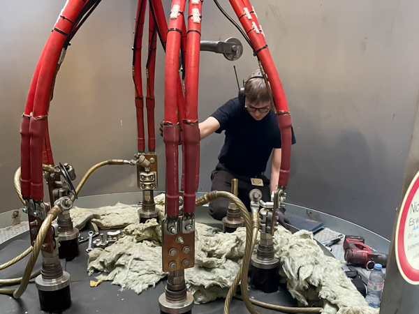 Service work inside an industrial electrode boiler, inspecting electrodes and high-voltage cables during maintenance in Nuremberg.