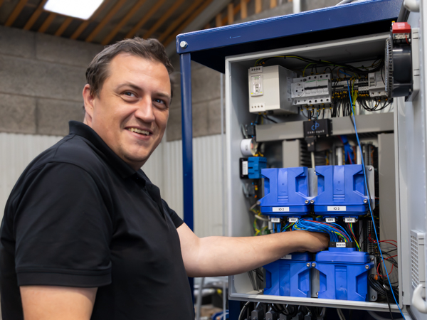 Tekniker inspicerer elektrisk styring i Turner Gear kontrolstation til vindmølleinstallation