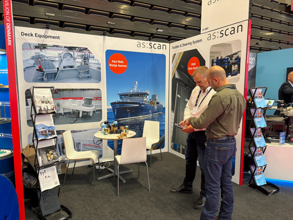 AS SCAN technician and customer looking at a mobile phone at AS SCAN’s stand D-380 during Nor-Fishing 2026 in Trondheim.