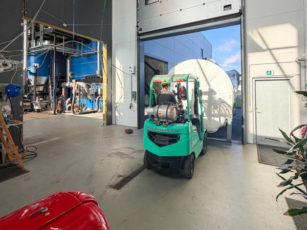 The electric boiler being moved into the boiler hall with a forklift at Løgumkloster Fjernvarme.
